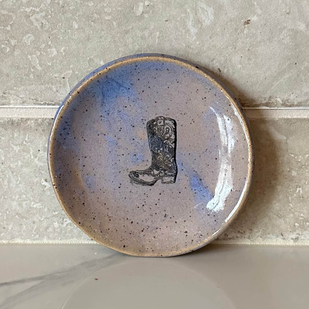 Ceramic plate with a cowboy boot design on a speckled surface